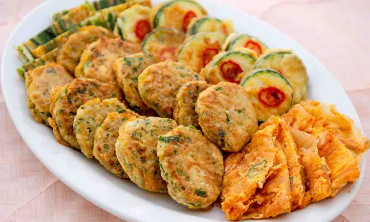 Piatto di frittelle di una volta: polpette verdi, zucchine con peperoncino e sfoglie dorate. Un tripudio di sapori e colori.