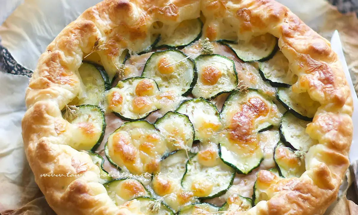 Deliziosa torta salata con zucchine, formaggio fuso e croccante pasta sfoglia. Perfetta per un pranzo leggero o un aperitivo.