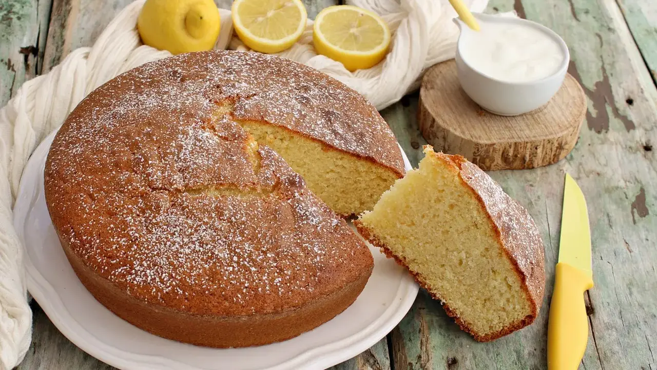 Una torta da colazione morbidissima, spolverata di zucchero a velo, con limoni e yogurt. Perfetta per iniziare la giornata con dolcezza.