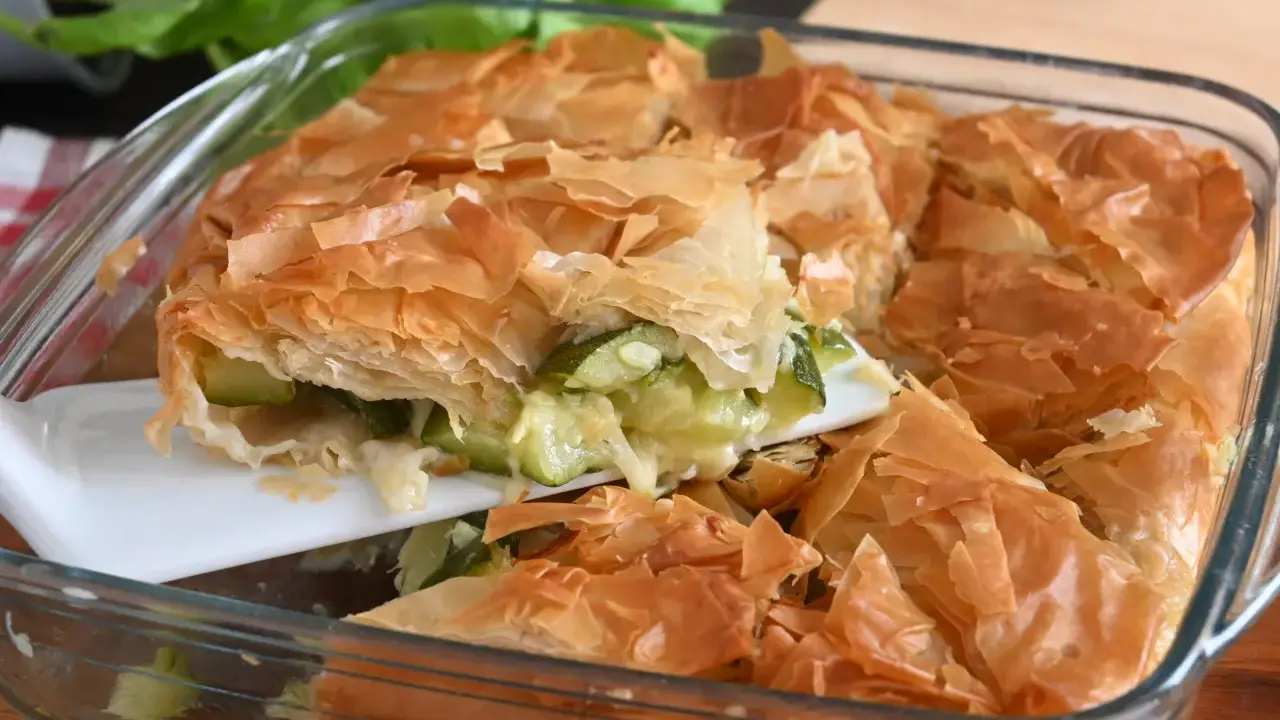 Torta salata con pasta sfoglia e zucchine, dorata e croccante, pronta per essere gustata.