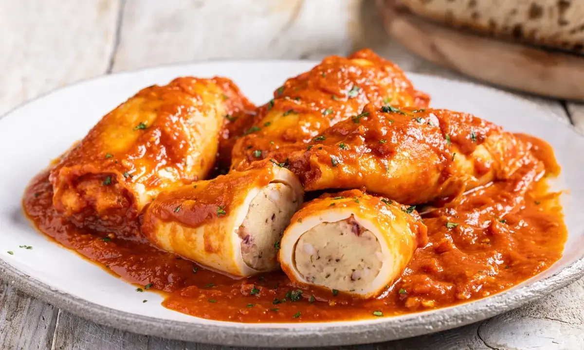 Totani al forno ripieni, un piatto succulento con un ripieno saporito, immersi in una ricca salsa rossa.