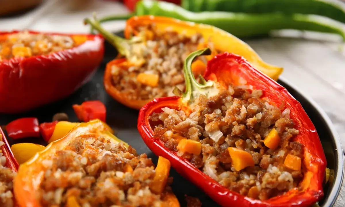 Peperoni ripieni senza carne, un piatto colorato e saporito. Peperoni rossi, gialli e arancioni farciti con un gustoso ripieno.