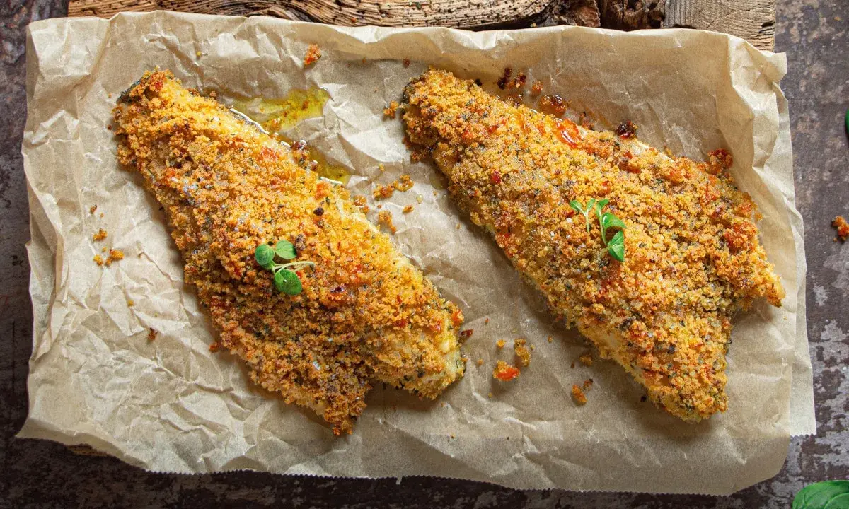 Filetti di orata al forno con crosta croccante, serviti su carta da forno.