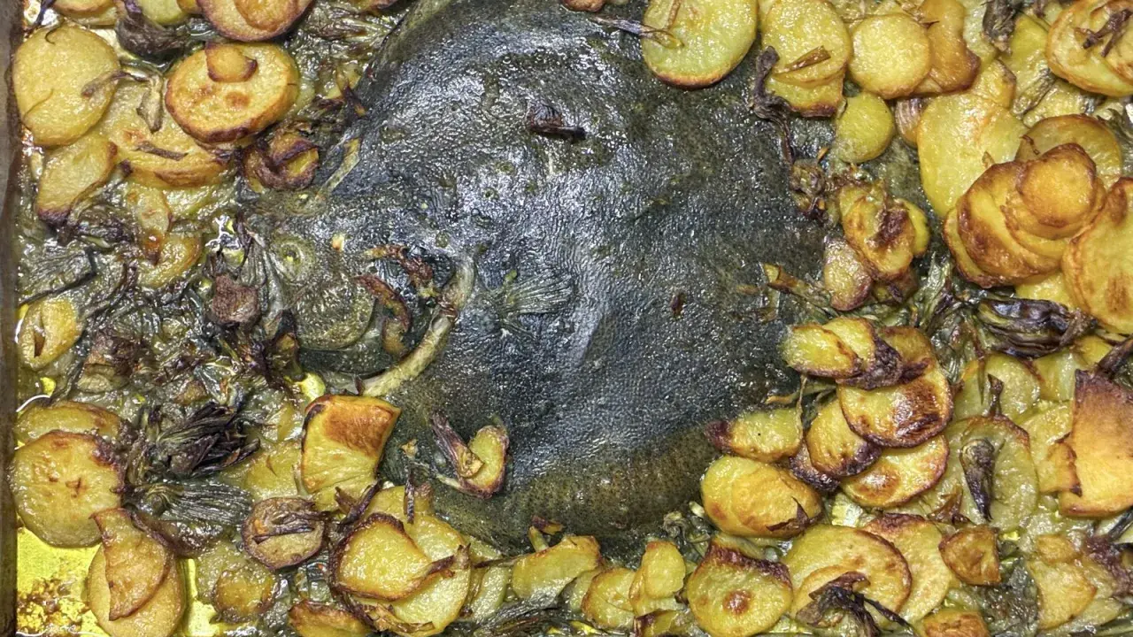 Rombo al forno con patate dorate e cipolle caramellate, un piatto succulento e profumato pronto per essere gustato.
