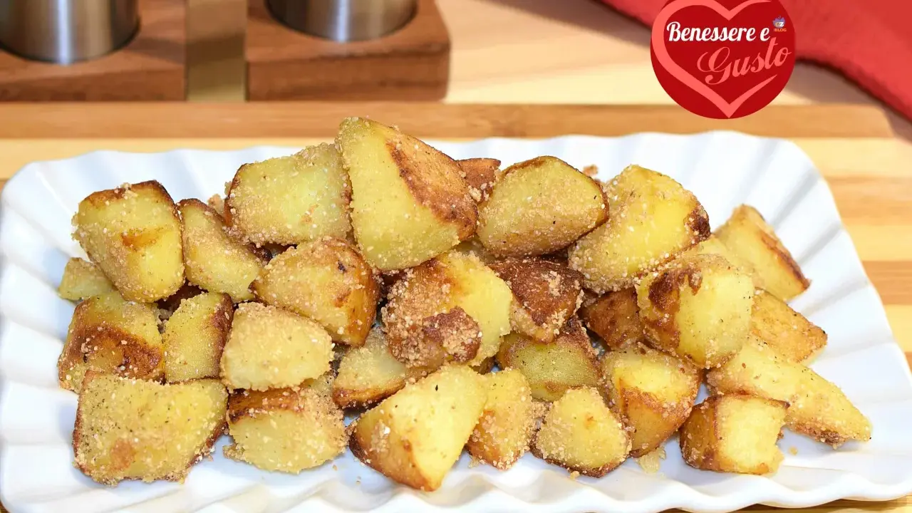 Patate sabbiose in padella, dorate e croccanti, servite su un piatto bianco. Un contorno irresistibile per ogni pasto.