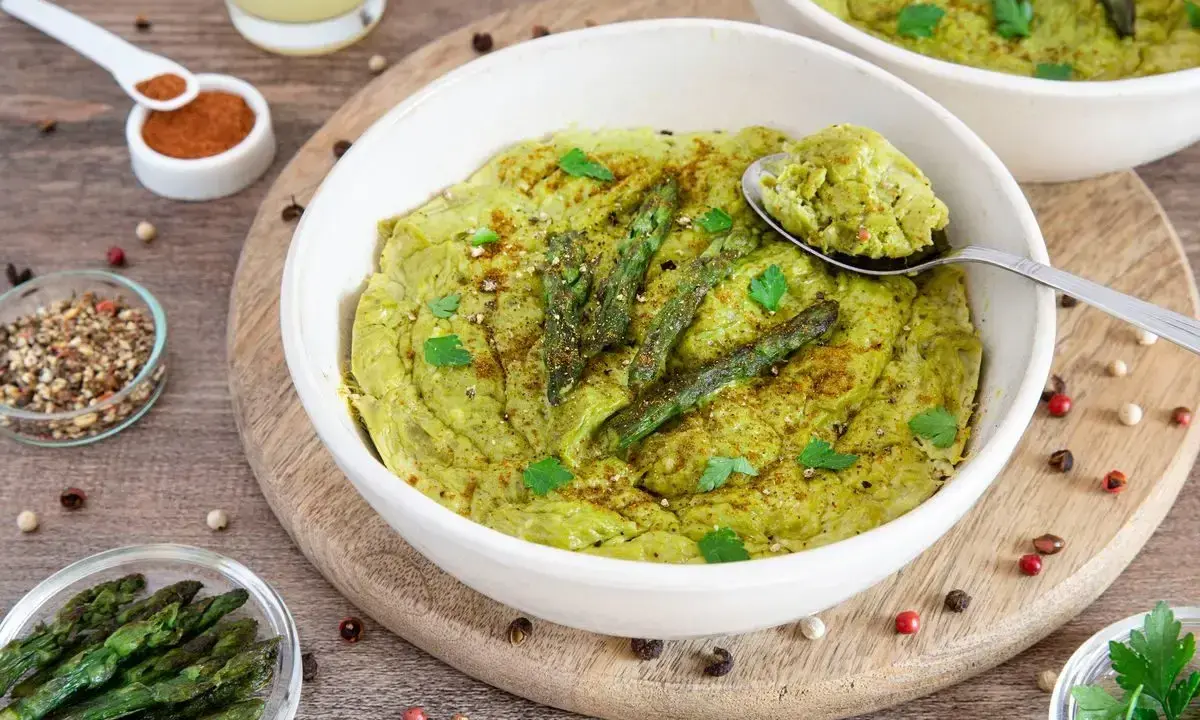 Delizioso flan di asparagi, guarnito con punte di asparagi freschi e prezzemolo, pronto per essere gustato.
