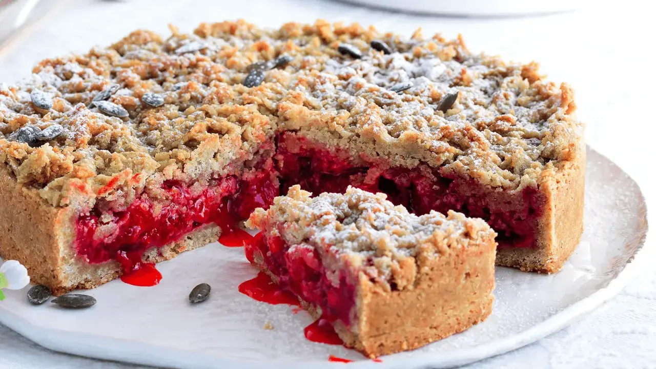 Sbriciolata con ripieno succoso di frutti rossi, cosparsa di zucchero a velo e semi. Perfetta per celebrare la Pasqua con un tocco goloso.
