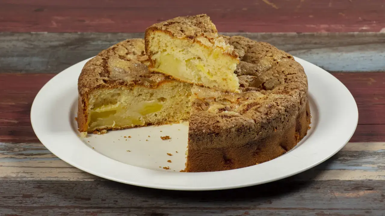 Una fetta di torta di mele, soffice e dorata, con un crumble croccante. Sembra la torta di mele più buona che abbia mai mangiato.