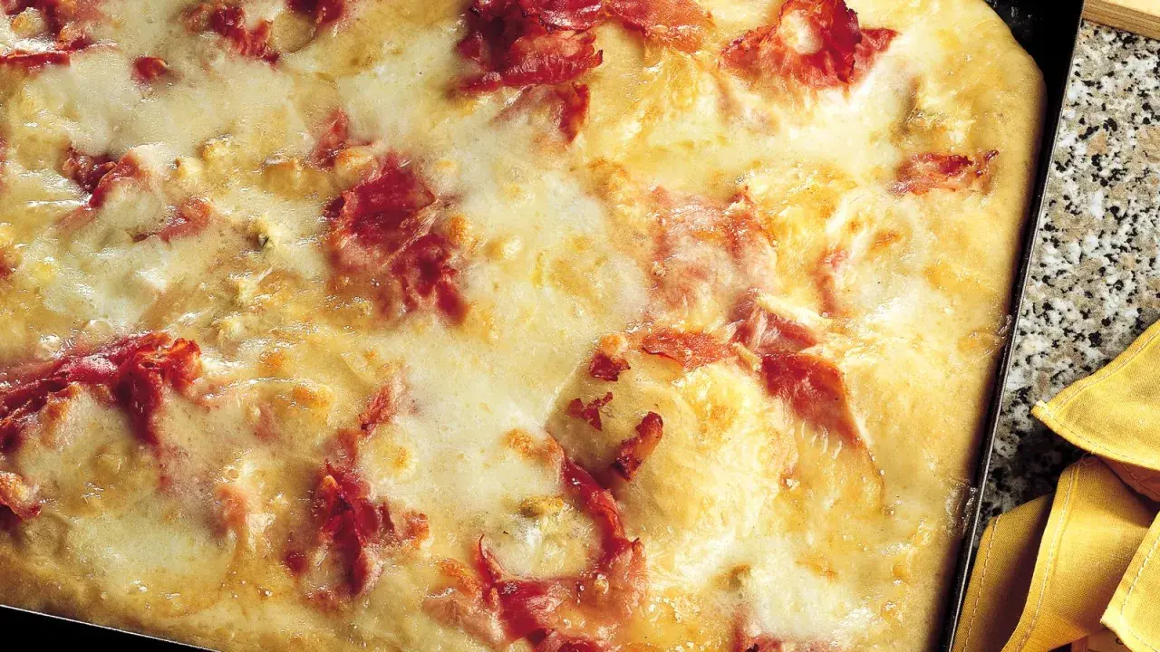 Pizza di patate filante con prosciutto croccante, un piatto invitante e gustoso.