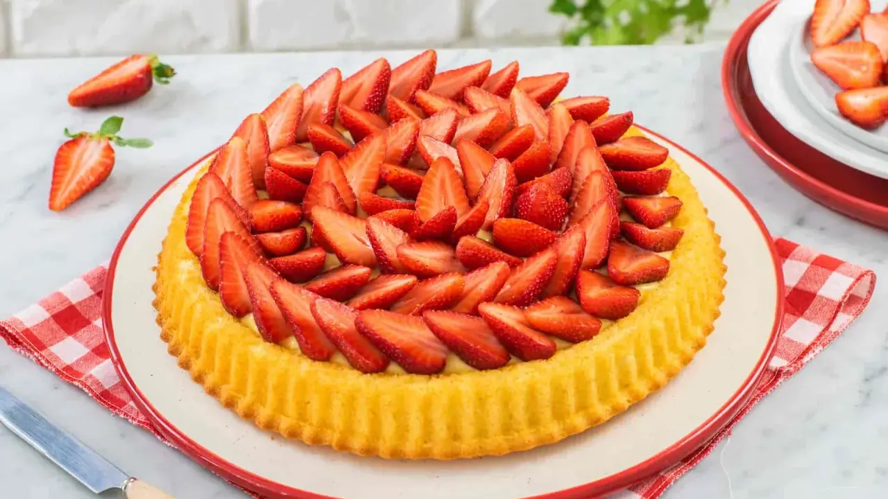 Una deliziosa crostata morbida alle fragole, ricca di frutta fresca e crema, pronta per essere gustata.