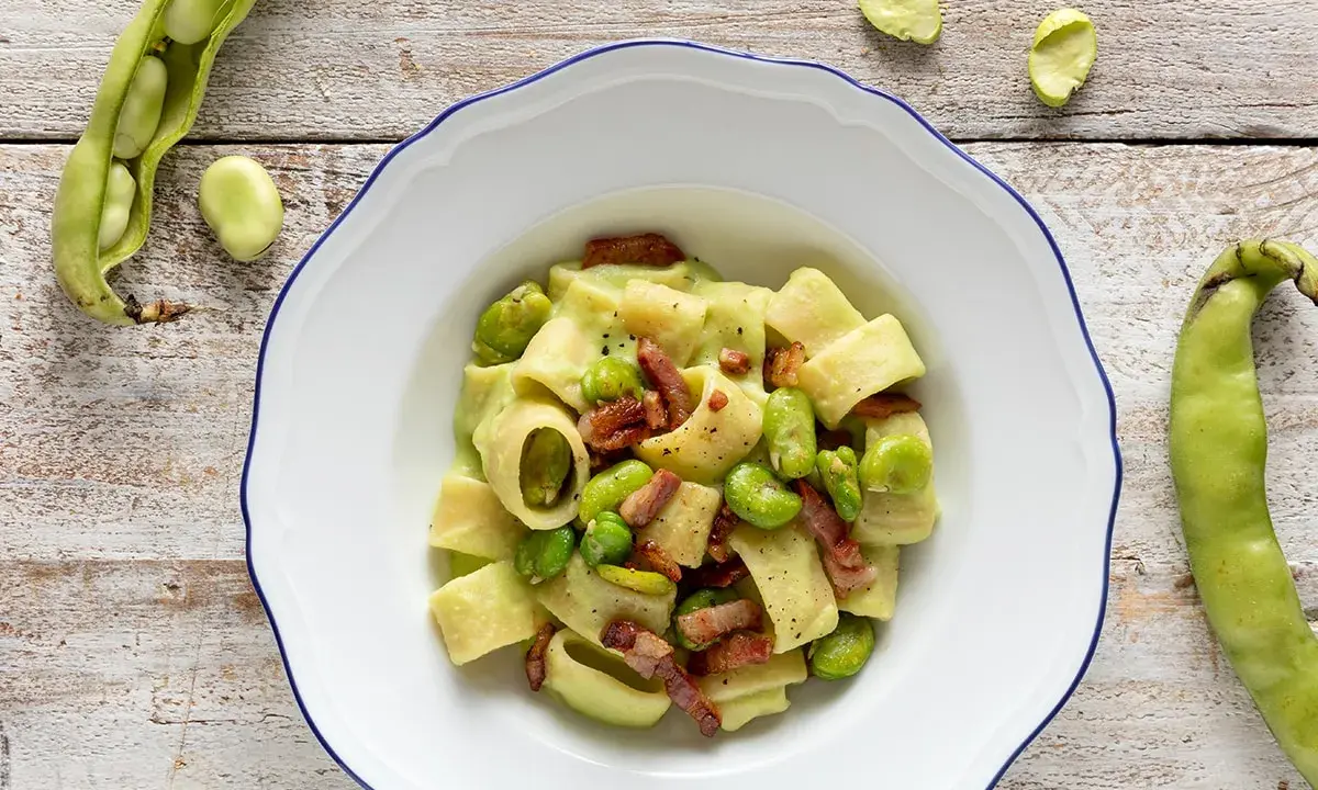 Piatto di pasta con fave fresche e croccante pancetta, un classico saporito.