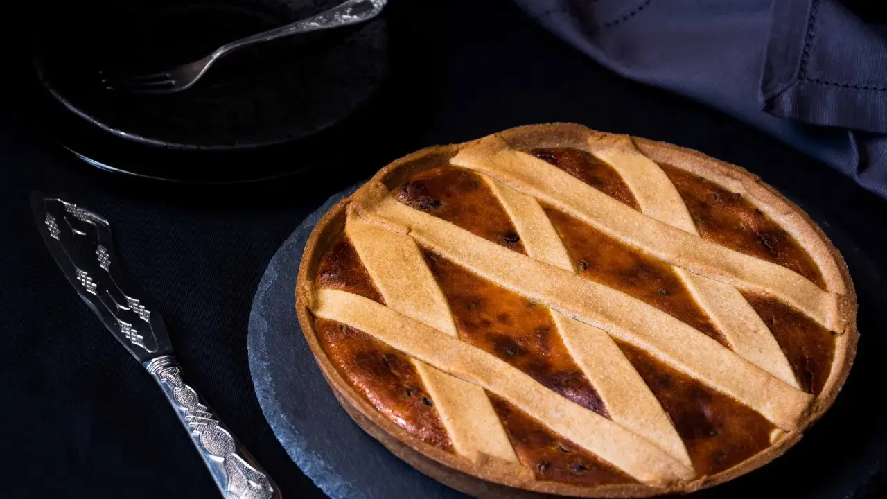 Una deliziosa crostata di ricotta, con una griglia dorata di pasta frolla, pronta per essere gustata.
