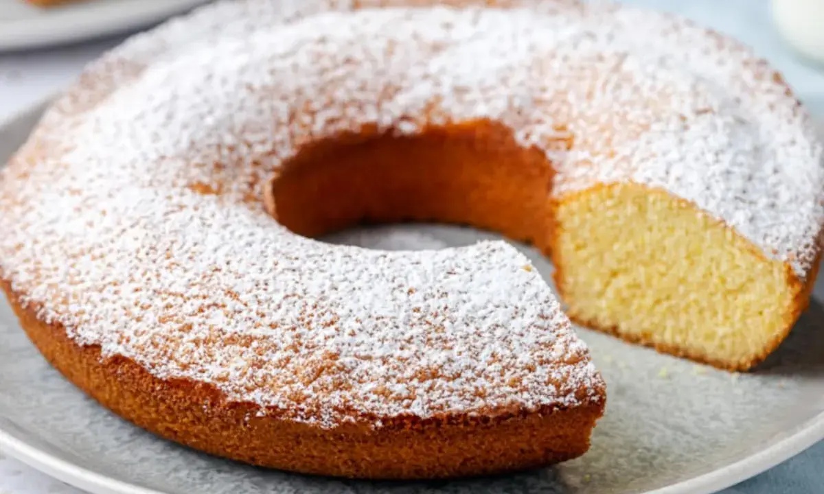 Ciambella senza glutine, soffice e dorata, cosparsa di zucchero a velo. Perfetta per una colazione o merenda golosa e leggera.
