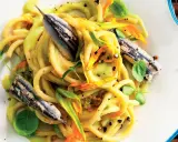 Pasta con fiori di zucca e alici, un piatto estivo colorato e saporito, con erbe fresche e pepe nero.