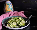Fetta di zucchine marinate crude condite con erbe aromatiche e olio, servite su un piatto verde.
