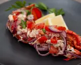 Astice alla catalana: polpa di astice sfilacciata con pomodoro, cipolla rossa e limone, guarnito con prezzemolo.