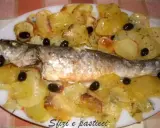 Branzino al forno con patate e olive nere, un piatto saporito e profumato, pronto per essere gustato.