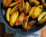 Patate in padella croccanti, dorate e profumate al rosmarino, pronte per essere gustate.