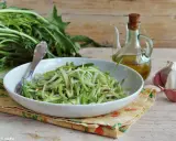 Un piatto di puntarelle alla romana, condite con olio e aglio, pronte per essere gustate.