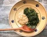 Piatto rustico con fave e cicoria, un classico della cucina italiana, servito su un piatto decorato con fiori blu.