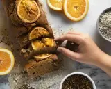 Un profumato plumcake all'arancia, uno dei tanti dolci senza glutine, pronto per essere gustato. Accanto, arance fresche e avena.