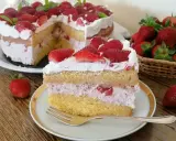 Una fetta di torta mascarpone e fragole, con strati di pan di spagna, crema rosa e fragole fresche, guarnita con panna e fragole.
