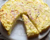 Una fetta di torta di patate filante, dorata e profumata al rosmarino, pronta per essere gustata.