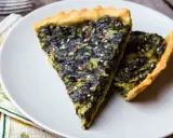 Fette di torta salata vegana con spinaci e semi di lino, su un piatto bianco.