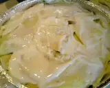 Crespelle con asparagi pronte per essere infornate, ricoperte da una cremosa besciamella.