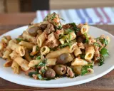 Piatto di pasta al tonno con olive verdi e prezzemolo fresco, servita su un piatto bianco.