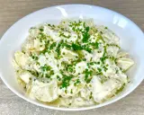 Una cremosa insalata di patate, condita con erbe aromatiche e guarnita con erba cipollina fresca. Perfetta per un picnic o un pranzo leggero.