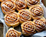 Dolci con lievito di birra, soffici girelle alla cannella con glassa bianca, pronte per essere gustate.