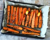 Carote al forno dorate e caramellate, condite con erbe aromatiche, pepe nero e spicchi d'aglio. Un contorno semplice e gustoso.