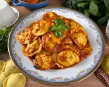 Piatto di ravioli ricotta e spinaci conditi con sugo rosso e basilico fresco. Ingredienti freschi e pasta fatta in casa.