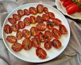 Pomodorini al forno, dorati e succosi, conditi con erbe aromatiche, pronti per insaporire ogni piatto.