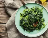 Piatto di puntarelle in padella, condite con aglio e peperoncino, pronte per essere gustate.