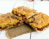 Tre fette di torta con marmellata, legate con spago, su carta da forno e tela di juta.