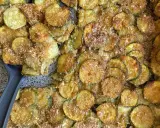 Fette di zucchine gratinate al forno, dorate e croccanti, pronte per essere servite.