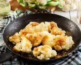 Cavolfiore in padella, dorato e saporito, pronto per essere gustato.