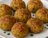 Polpette dorate di zucchine e tonno, guarnite con prezzemolo fresco, pronte per essere gustate.