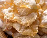 Chiacchiere croccanti, dolci e leggere, come quelle della ricetta della nonna, cosparse di zucchero a velo.