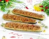 Zucchine ripiene tonno, dorate e croccanti, servite su un piatto bianco con erbe aromatiche.