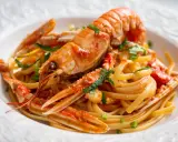 Un piatto invitante di linguine agli scampi, con pasta fresca e scampi succulenti conditi con un sugo saporito e prezzemolo tritato.