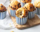 Muffin con gocce di cioccolato, perfetti per la friggitrice ad aria. Uno è stato morso, rivelando un interno soffice e goloso.