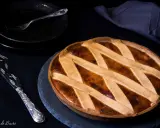 Una deliziosa crostata di ricotta, con una griglia dorata di pasta frolla, pronta per essere gustata.