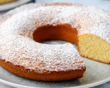 Ciambella senza glutine, soffice e dorata, cosparsa di zucchero a velo. Perfetta per una colazione o merenda golosa e leggera.