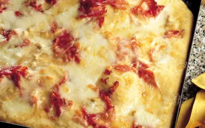 Pizza di patate filante con prosciutto croccante, un piatto invitante e gustoso.