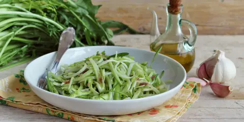 Un piatto di puntarelle alla romana, condite con olio e aglio, pronte per essere gustate.