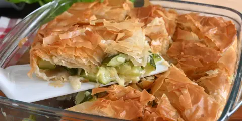 Torta salata con pasta sfoglia e zucchine, dorata e croccante, pronta per essere gustata.