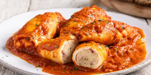 Totani al forno ripieni, un piatto succulento con un ripieno saporito, immersi in una ricca salsa rossa.